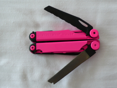 Hot pink powdercoated Leatherman front view closed with blades spread